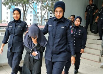 PUTERI Nurin Amalina Ahmad Daud (tengah) dibawa ke Mahkamah Sesyen Seremban semalam bagi didakwa atas empat pertuduhan melakukan penderaan fizikal dan penganiayaan terhadap empat kanak-kanak perempuan di sebuah pusat jagaan kanak-kanak di Rasah, Seremban Ogos lalu.-UTUSAN/MOHD. SHAHJEHAN MAAMIN.