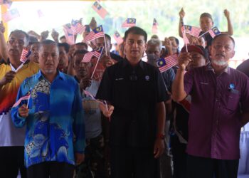 MUHAMMAD Faiz Fadzli (tengah) mengibarkan Jalur Gemilang semasa  Majlis Penyerahan Bantuan Peralatan Penangkapan Ikan B40 dan Pelancaran Kibar Jalur Gemilang Bot Nelayan di LKIM Kuala Besar, Kota Bharu, Kelantan-UTUSAN/KAMARUL BISMI KAMARUZAMAN.