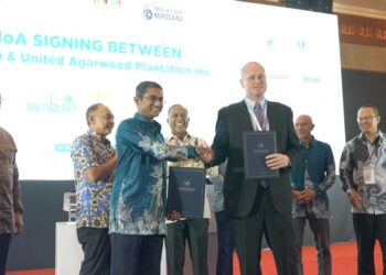 Ketua Pegawai Eksekutif UMPSA Holdings Sdn. Bhd. Syed Alwi Mohamed Sultan dan Ketua Pegawai Eksekutif Iba Botanicals Inc. Benjamin Mead bertukar-tukar dokumen  perjanjian yang dimeterai sambil diperhatikan oleh Pengerusi Majlis Penasihat Perniagaan ASEAN Malaysia Tan Sri Mohamed Nazir Tun Abdul Razak dan Menteri Pengajian  Tinggi Dato’ Seri Ditaja Dr Zambry Abd Kadir.