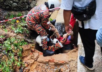 ANGGOTA bomba dilihat bertungkus-lumus untuk membawa keluar seorang wanita yang dipercayai terjatuh ke dalam satu lubang saluran air sedalam enam kaki di Cherok Tokun, Bukit Mertajam, Pulau Pinang.-GAMBAR/EHSAN JBPM PULAU PINANG