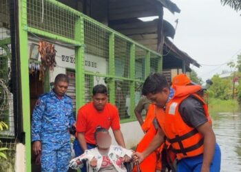 BEBERAPA anggota APM Pulau Pinang membantu memindahkan seorang mangsa banjir di Nibong Tebal, Pulau Pinang petang tadi.-GAMBAR/APM PULAU PINANG