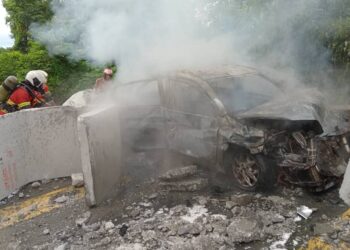 ANGGOTA bomba memadamkan kebakaran melibatkan sebuah kereta yang melanggar bongkah konkrit yang jatuh dari sebuah treler dalam kejadian di Jalan Mambau-Seremban 2, Seremban pagi tadi.-GAMBAR/IHSAN BOMBA