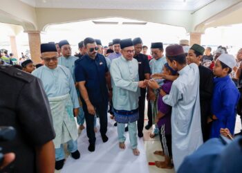 Anwar Ibrahim beramah mesra dengan orang ramai selepas menunaikan solat jumaat di Masjid Darussalam, Puchong, di sini hari ini. Foto: SHIDDIEQIIN ZON