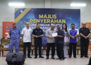 SHAMSUL Iskandar Mohd. Akin (empat dari kiri) menyerahkan sumbangan kepada seorang mangsa banjir di Sungai Dua, Butterworth, Pulau Pinang.-UTUSAN/IQBAL HAMDAN