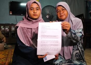 SITI Zulaikha (kiri) bersama ibunya menunjukkan surat yang dihantar kepada Perdana Menteri ketika ditemui di rumahnya di Kampung Bukit Gading, Tanah Merah, Kelantan-UTUSAN/ROHANA ISMAIL