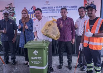 NGA Kor Ming membuang sampah sebagai simbolik pra-pelancaran Hari Cuci Malaysia di FIKS, Putrajaya. - UTUSAN/FAIZ ALIF ZUBIR