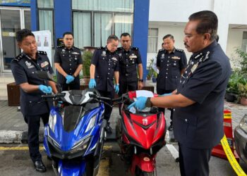 HAMZAH (kanan) meneliti dua buah motosikal yang digunakan dua orang suspek ketika menyamun dalam sidang akhbar di IPD Seberang Perai Selatan, di Nibong Tebal, Pulau Pinang.-UTUSAN/SITI NUR MAS ERAH AMRAN