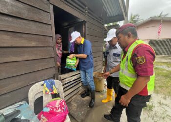 MOHD. Shukri Ramli (tiga dari kanan) menyerahkan bantuan di salah sebuah rumah terjejas akibat banjir di Kampung Titi Besi, Arau, Perlis hari ini. -UTUSAN/ASYRAF MUHAMMAD