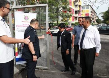 MOHD. Fauzi Mohd. Yatim (tiga dari kiri) menolak pintu pagar laluan alternatif dari Taman Sri Lembayung ke Plaza Tol Sri Muda sebagai gimik perasmian laluan tersebut hari ini.