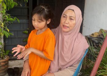 FADZILAH Bakar (kanan) sebak menceritakan mengenai Allahyarham Elly Idzlianizar Elias yang maut dengan kesan 12 tetakan ketika ditemui di rumahnya di Taman Fauziah, Kangar, Perlis hari ini. -UTUSAN/ASYRAF MUHAMMAD