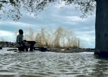 IMRAN Pejor melihat ombak yang membadai di hadapan rumahnya berikutan fenomena air pasang besar dan hujan lebat di pesisir pantai Kurung Tengar, Kuala Perlis, Perlis semalam.-UTUSAN/ASYRAF MUHAMMAD