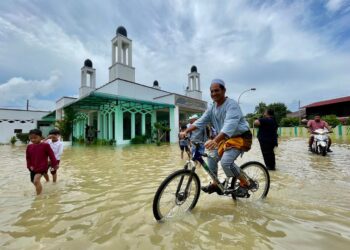 SEORANG jemaah berbasikal ketika hadir menunaikan solat Jumaat di Masjid Tuan Hussein yang turut dinaiki air di Titi Gajah, Alor Setar. - UTUSAN/ SHAHIR NOORDIN