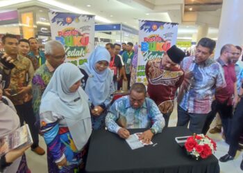 MUHAMMAD Sanusi Md Nor (tengah) sedang menandatangani novel mengenai sejarah hidupnya bertajuk ‘Dinding Sekeping Adik Seorang’ yang dibeli orang ramai sempena Pesta Buku Kedah 2024 di Sungai Petani.