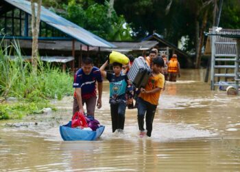 PENDUDUK mengangkut barangan keperluan mereka untuk ke PPS setelah rumah mereka dinaiki air di Kampung Padang Luar, Jitra di Kubang Pasu. - UTUSAN/ SHAHIR NOORDIN