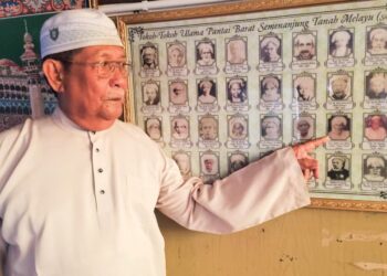 OMAR Abdul Aziz menunjukkan gambar bapanya, Allahyarham  Tuan Guru Abdul Aziz Mohd.  A’qib  yang tersenarai sebagai antara tokoh ulama negara. – MINGGUAN/AIN SAFRE BIDIN