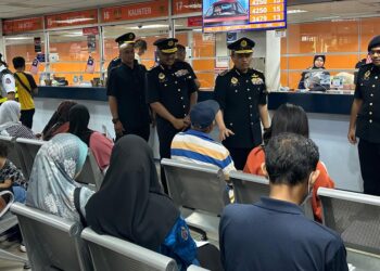 AEDY Fadly Ramli (tengah) beramah mesra bersama pelanggan yang menunggu giliran di JPJ Seberang Jaya, Pulau Pinang, semalam.