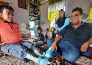 MUHAMMAD Adam Hanif (kiri) bersama Mohd. Faisal Shahri dan ahli keluarganya di Kampung Sidam Kanan, Padang Serai di Kulim, Kedah. –  UTUSAN/ AZAHAR HASHIM