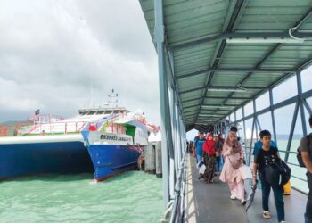 PENUMPANG yang bercuti di Pulau Langkawi tiba di Terminal Feri Penumpang Kuah, Langkawi, Kedah. – UTUSAN/ NUR AMALINA AZMAN