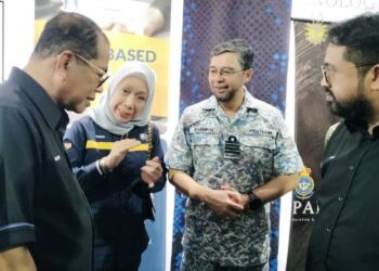 Faizah Abd Majid (dua dari kiri) menerangkan tentang Projek Work Based Award (WBA) UiTM@WBL MINDEF kepada Mohamed Khaled Nordin (kiri) selepas meluncurkan Minggu Bersama Pencarum Wilayah Selatan di Kem Mahkota, Kluang, semalam.