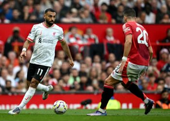 PENYERANG Liverpool, Mohamed Salah (kiri) cuba melepasi pertahanan Manchester United, Diogo Dalot ketika kedua-dua pasukan bertemu dalam aksi liga di Old Trafford yang berkesudahan The Reds menang 3-0. - AFP