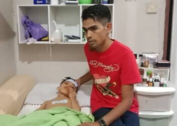 MOHAMAD Nooruldzat Nasir (kanan) bersama Mohamad Nurimanramdani yang menderita penyakit Leukodystrophy di Taman Ria di Jerantut, Pahang. - UTUSAN/HARIS FADILAH AHMAD