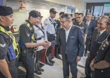 SAIFUDDIN Nasution Ismail beramah mesra dengan anggota polis selepas Majlis Perhimpunan Bulanan Kementerian Dalam Negeri (KDN) di Kompleks Setia Perkasa, Putrajaya, semalam. – UTUSAN/FAIZ ALIF ZUBIR