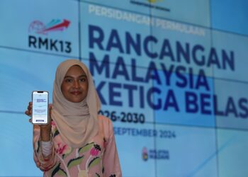 SEORANG peserta menunjukkan aplikasi portal RMK13. - UTUSAN/FAISOL MUSTAFA