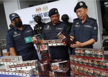 Pengarah Operasi Penguatkuasaan Zon Tengah Kastam, Wong Pun Sian (kanan) melihat rokok seludup yang dirampas Jabatan Kastam melalui Unit Siasatan Frod Perdagangan (USFP) di Dengkil pada Ogos lalu. - UTUSAN/FAISOL MUSTAFA