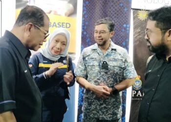 Faizah Abd Majid (dua dari kiri) menerangkan tentang Projek Work Based Award (WBA) UiTM@WBL MINDEF kepada Khaled Nordin (kiri) selepas meluncurkan Minggu Bersama Pencarum Wilayah Selatan di Kem Mahkota, Kluang hari ini.