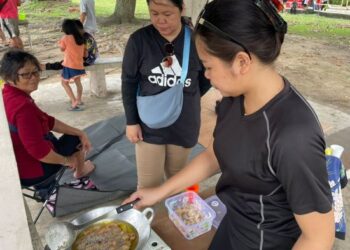 BIANA Jilih (tengah) bersama keluarga sibuk menyiapkan makanan untuk berkelah di Pantai Tanjung Aru, Kota Kinabalu.