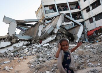 SEORANG kanak-kanak perempuan berdiri di depan bangunan sekolah yang runtuh akibat bedilan tentera Israel di Khan Younis, selatan Semenanjung Gaza, Palestin. - AFP