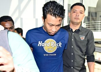 MOHD. Syahid Hanapiah dibawa anggota polis ke Mahkamah Sesyen Selayang Selayang untuk dituduh kerana merotan kanak-kanak. - UTUSAN/SYAKIR RADIN