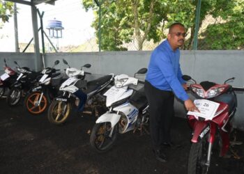 MUHAMMAD Firdaus Shariff melihat sebahagian daripada motosikal untuk dilelong pada Program Pelelongan Awam Kenderaan Lucut Hak 2024 di JPJ Bukit Katil, Melaka. UTUSAN/AMRAN MULUP