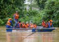 ANGGOTA Angkatan Pertahanan Awam (APM) memindahkan mangsa banjir dari kawasan rumah mereka yang ditenggelami banjir di Kampung Alor Madi di Anak Bukit, Alor Setar. - UTUSAN/ SHAHIR NOORDIN