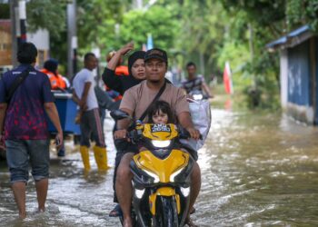 PENDUDUK berpindah keluar setelah limpahan air Sungai Anak Bukit semakin tinggi di Kampung Alor Madi, Alor Setar. - UTUSAN/ SHAHIR NOORDIN