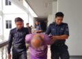 SUSPEK diiringi anggota polis ketika dibawa untuk mendapatkan perintah reman di Mahkamah Majistret, Ayer Keroh, Melaka.