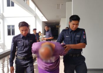 SUSPEK diiringi anggota polis ketika dibawa untuk mendapatkan perintah reman di Mahkamah Majistret, Ayer Keroh, Melaka.