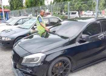 HANYAN Ramlan memeriksa salah sebuah kereta yang disita dalam Op Lumba Haram di Ibu pejabat Polis Daerah (IPD) Kemaman, Terengganu, semalam. – UTUSAN/NIK NUR IZZATUL HAZWANI NIK ADNAN