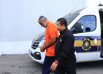 GUL Siraj (kiri) dibawa oleh pegawai SPRM untuk didakwa atas pertuduhan memberi rasuah sebanyak RM200 kepada pegawai polis di Mahkamah Sesyen Kota Bharu, Kelantan hari ini. - UTUSAN/KAMARUL BISMI KAMARUZAMAN