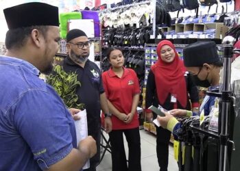 ASMADI Abdul Rahman (dua, kiri) bersama pegawai MUIP menyantuni anak bekas ahli GISBH membeli barangan keperluan persekolahan di sebuah pasar raya di Kuantan, Pahang, semalam. - UTUSAN/DIANA SURYA ABD WAHAB