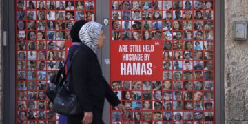 PINTU masuk sebuah kedai di jalan King George di Baitulmuqaddis memaparkan sepanduk dengan potret warga Israel yang menjadi tebusan di Gaza.- AFP