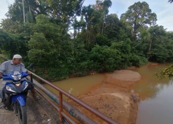 KADIR Daud meninjau keadaan Sungai Por yang semakin cetek di Kampung Kemat, Hulu Terengganu, semalam. – UTUSAN/NOOR HAYATI MAMAT