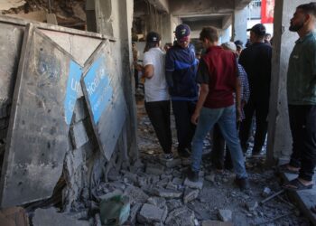 PENDUDUK Palestin memeriksa kerosakan di dalam sekolah yang dijadikan tempat perlindungan di kem pelarian Al-Shati berhampiran Gaza City.-AFP