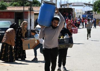 RAKYAT Syria dan Lubnan yang terpaksa berpindah membawa barangan mereka memasuki Syria melalui persimpangan sempadan Jusiyeh dengan Quseir, di wilayah Homs tengah Syria.- AFP