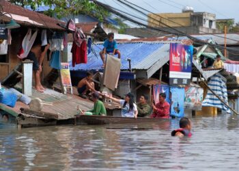 SUKARELAWAN membantu penduduk yang terperangkap di kawasan banjir di daerah Naga di Filipina.-AFP