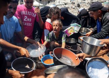 PENDUDUK Palestin berebut untuk mendapatkan makanan di dapur kem pelarian Bureij di Semenanjung Gaza.-AFP