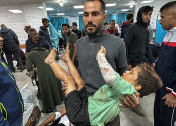 SEORANG lelaki warga Palestin mendukung kanak-kanak yang cedera dalam pengeboman Israel di Hospital Kamal Adwan di Beit Lahia di utara  Gaza.-AFP