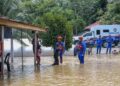 ANGGOTA Angkatan Pertahanan Awam (APM) meninjau kawasan rumah yang dilanda banjir di Kampung Kubang Betong, Changlun di Kubang Pasu. - UTUSAN/ SHAHIR NOORDIN