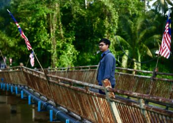 MUHAMMAD Amir Hakimi Sabari merenung ke arah Sungai Padang Terap yang menjadi lokasi dipercayai bapanya dibuang oleh suspek di Kampung Empa, Kubang Pasu. - UTUSAN/ SHAHIR NOORDIN