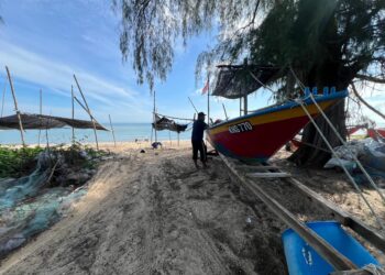 NELAYAN memindahkan sampan mereka ke tempat selamat sebagai persiapan menghadapi musim tengkujuh di  Pantai Pachakan, Pasir Puteh, Kelantan. – UTUSAN/TOREK SULONG